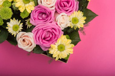 Pembe arka planda hediye kutusunda taze güller