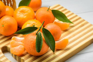 Beyaz ahşap masada taze ve sulu mandalina.