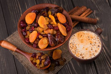 Ahşap arka planda kurutulmuş meyve aromalı kahve fincanı.