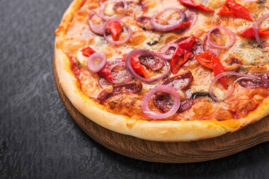 Tahta üzerinde salamlı, soğanlı ve pepperonili lezzetli pizza.