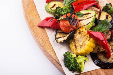 Kesme tahtasındaki ızgara sebzeler beyaz arka planda izole edilmiş.