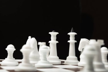 Tahtada beyaz ve siyah satranç taşları