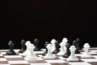 Siyah arkaplanda satranç piyonları.