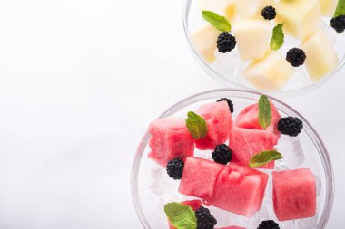 Beyaz arka planda izole edilmiş naneli ve buzlu lezzetli kavun parçası.