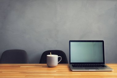 Kahve fincanı ve laptop ofis masasında. modern işyeri stüdyosu