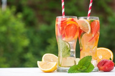 Limonlu çilekli limonata ve açık havada tahta beyaz masa üzerinde nane şekeri.