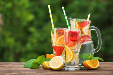 Mojito kokteyli ve malzemeler, limon, çilek ve portakal, açık havada.