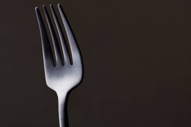 Siyah arkaplanda siyah çatal ve bıçak var.