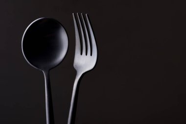 Siyah arka planda siyah çatal ve kaşık