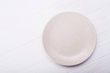 Ahşap arka planda boş seramik plaka. en üstteki görünüm