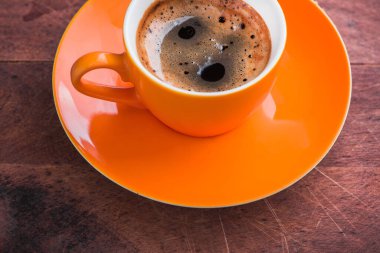 Eski ahşap arka planda lezzetli portakallı kahve fincanı yakın plan.