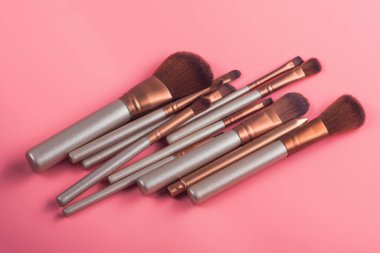 Pembe arka planda güzellik makyajı için kozmetik fırça