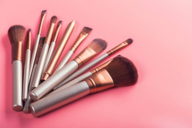 Pembe arka planda güzellik makyajı için kozmetik fırça