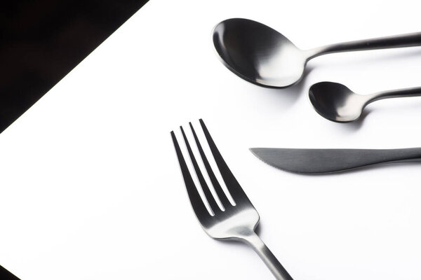 Cutlery set with black fork, knife and spoon isolated on white background