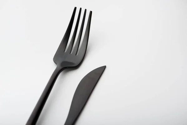 白を基調とした黒いフォークとナイフ — ストック写真