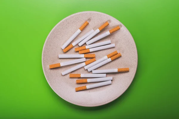 Vista Superior Del Plato Con Cigarrillos Tabaco Sobre Fondo Verde —  Fotos de Stock