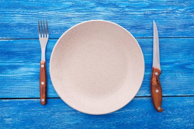 bıçak, çatal ve plaka mavi ahşap arka planda