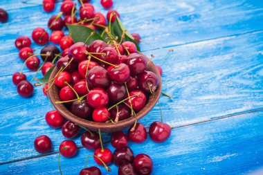 Mavi ahşap masada kırmızı taze kiraz meyvesi. Tatlı..