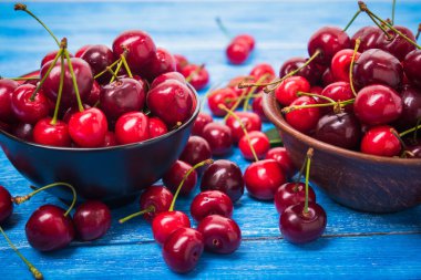 Mavi ahşap masada kırmızı taze kiraz meyvesi. Tatlı..