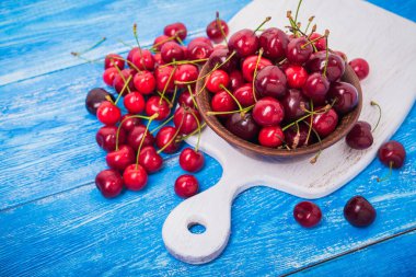 Mavi ahşap masada kırmızı taze kiraz meyvesi. Tatlı..