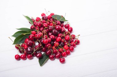 Beyaz ahşap arka planda taze kırmızı kiraz