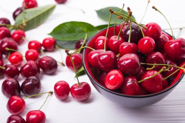 fresh red cherry fruit in plate on wood table clipart