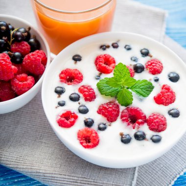 Ahşap mavi masada ahududulu lezzetli yoğurt. tatlı kahvaltı.