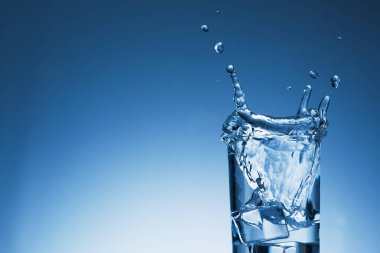 Arka planda su damlaları olan bir bardak.