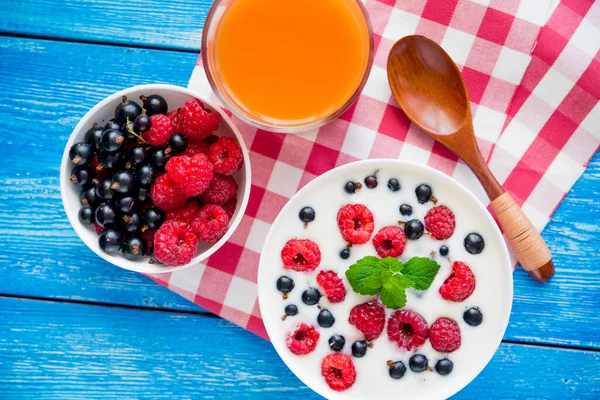 青い木のテーブルの上にフルーツとヨーグルトと健康食品と甘い朝食 — ストック写真