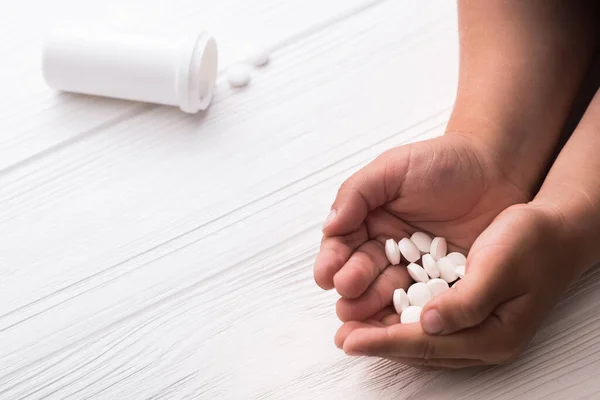 Main Enfant Avec Des Pilules Médicales Blanches Sur Fond Bois — Photo