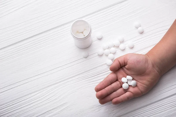 Main Enfant Avec Des Pilules Médicales Blanches Sur Fond Bois — Photo