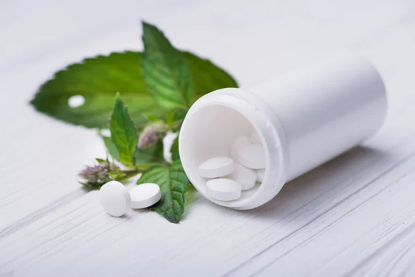 Pastillas Blancas Con Hoja Verde Sobre Fondo Blanco —  Fotos de Stock