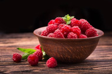 Yaz olgunlaşmış meyve kasesi. Arkadaki eski ahşap masa. ahududulu tatlı