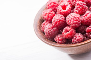 Tahta masadaki kasede taze kırmızı ahududu.