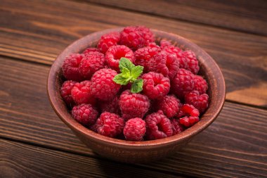 Kırsal ahşap masada kırmızı taze ahududu.