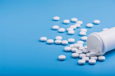 Mavi arka planda beyaz tıbbi haplar