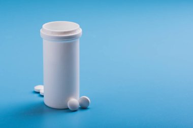 Mavi arka planda beyaz tıbbi haplar