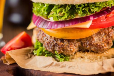 Domatesli ve ahşap masada sığır etli klasik burger. Fast food geçmişi