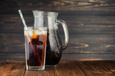 Kaliteli ahşap masada buz küplü kola bardağı. Soğuk içecek.