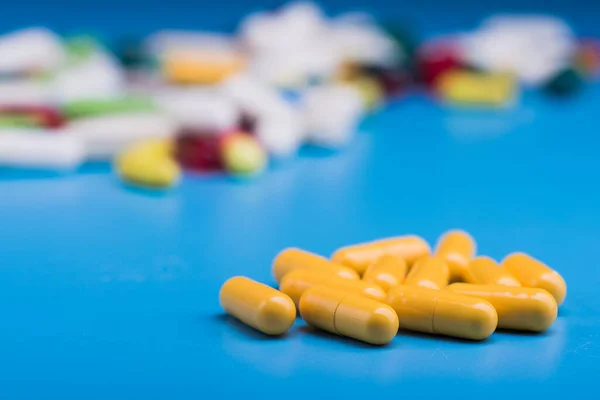 Желтые Медицинские Таблетки Капсула Синем Столе — стоковое фото