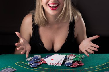 Siyah iç çamaşırlı seksi kız ve Kraliyet flaş kartlarıyla pokerde kazanıyor. Zaferde neşe ve kahkaha. Kumarhanede şans
