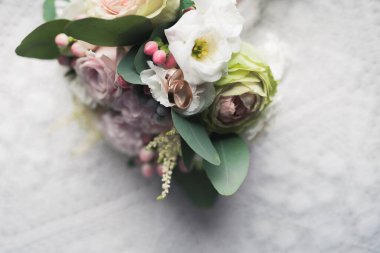 Düğün çiçeği buketi beyaz masada. Gül çiçeği süslemesi. Altın yüzükler