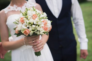 Gelin açık havada çiçek buketi tutuyor. romantik arkaplan