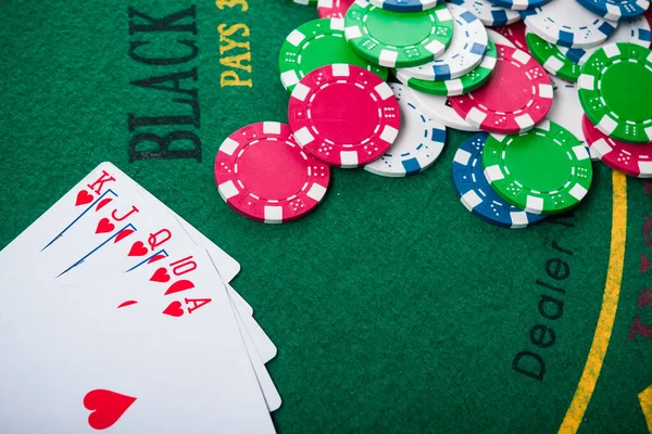 royal flash on cards and poker chips on green casino table. success in gambling