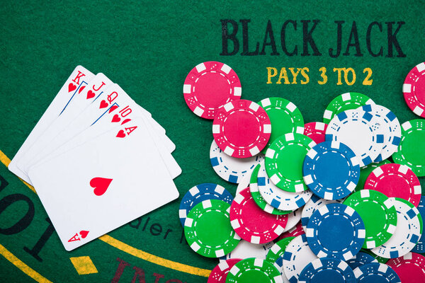 Королевская вспышка на картах и фишки для покера на зеленом столе казино. успех в азартных играх
