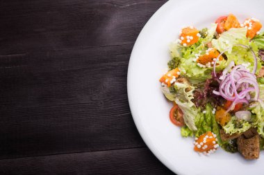 Kabaklı vejetaryen salatası, beyaz tabakta lahana ve domates, ahşap masa. en üstteki görünüm