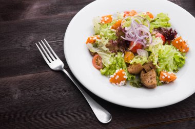 Kabaklı vejetaryen salatası, beyaz tabakta lahana ve domates, ahşap masa. en üstteki görünüm