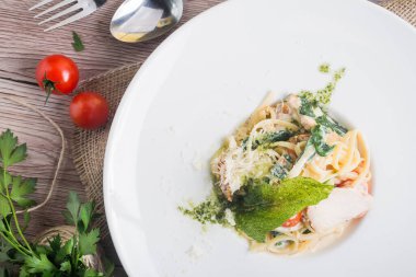 Beyaz tabakta tavuk ve domatesli makarna. en üstteki görünüm