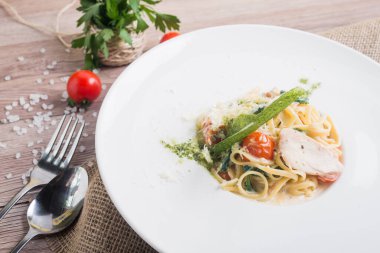 beyaz tabakta tavuk ve domatesli makarna