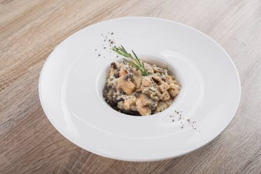 Mantarlı risotto ve beyaz tabakta biberiye. 